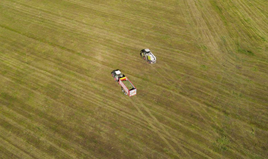 Legislação Ambiental — Drone view of tractors working on a vast field in Oberviechtach, Germany.