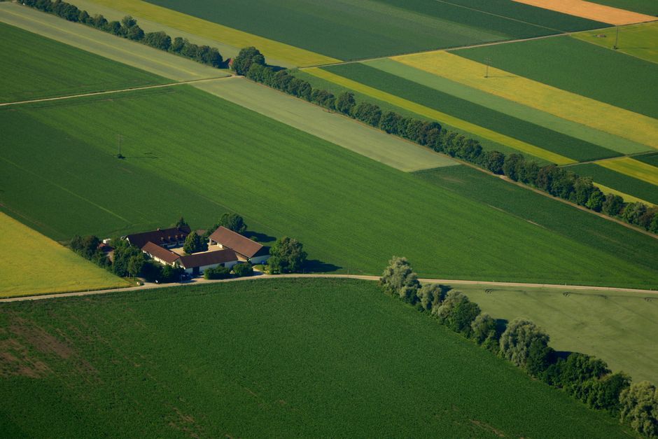 Legislação Ambiental — A stunning aerial shot of green fields and a countryside estate against a vibrant landscape.